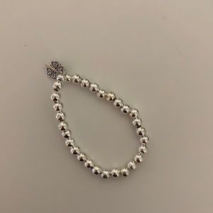 Silver bracelet with clover on it.